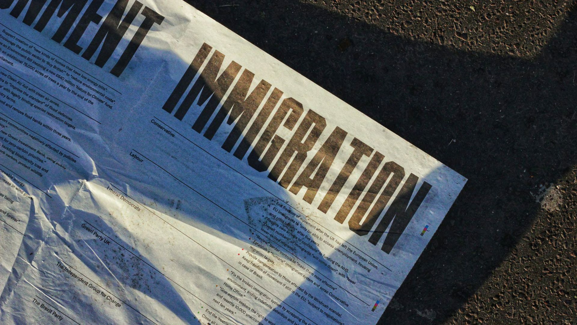 A close-up of a white paper about immigration that is on the road.