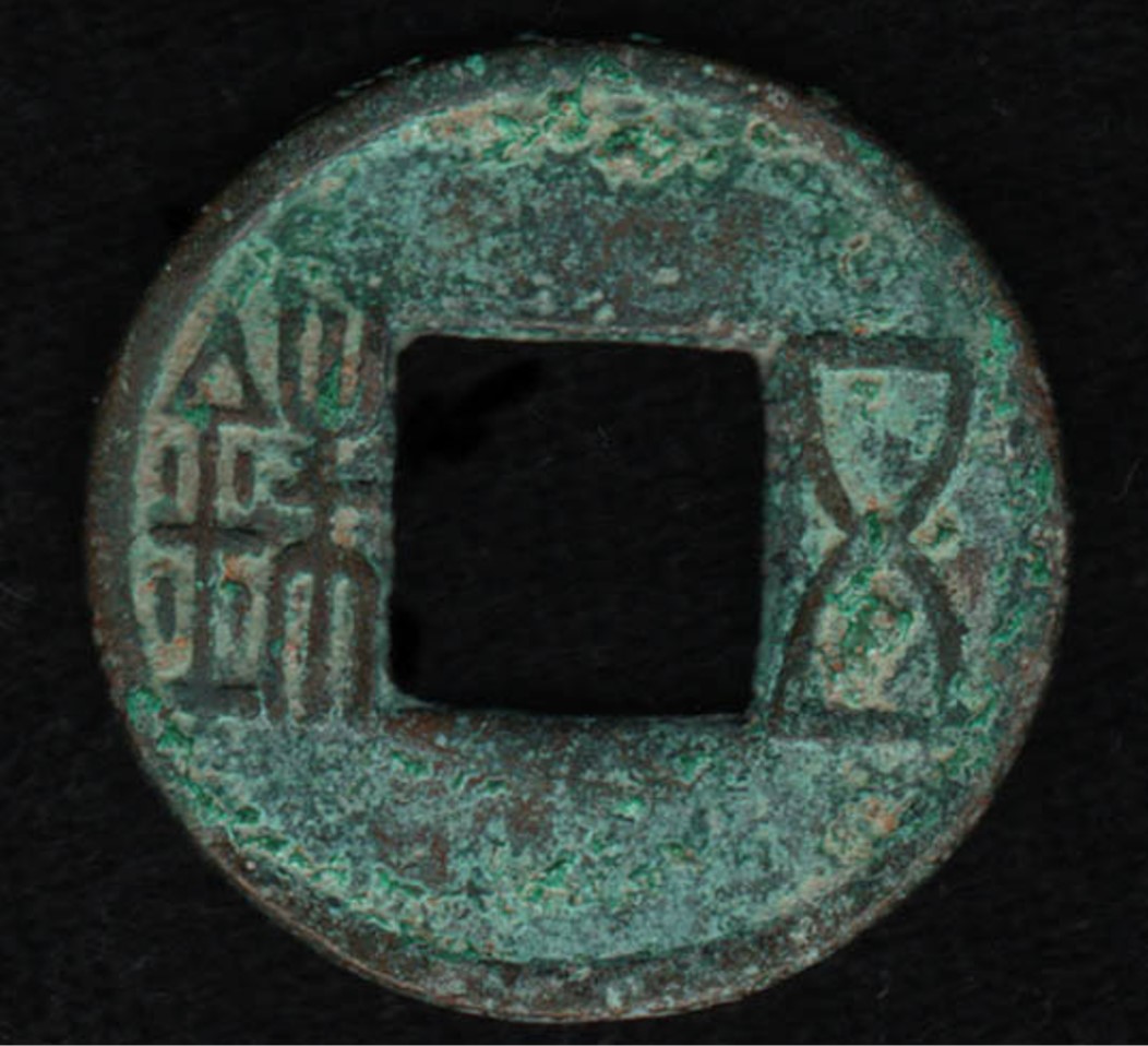 An ancient Chinese coin with several inscribed characters