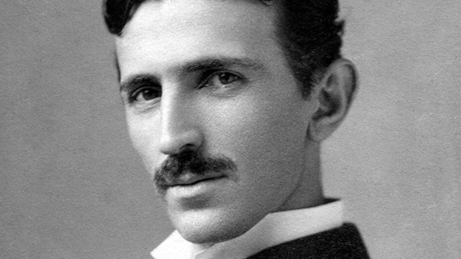 A black and white portrait of Nikola Tesla.