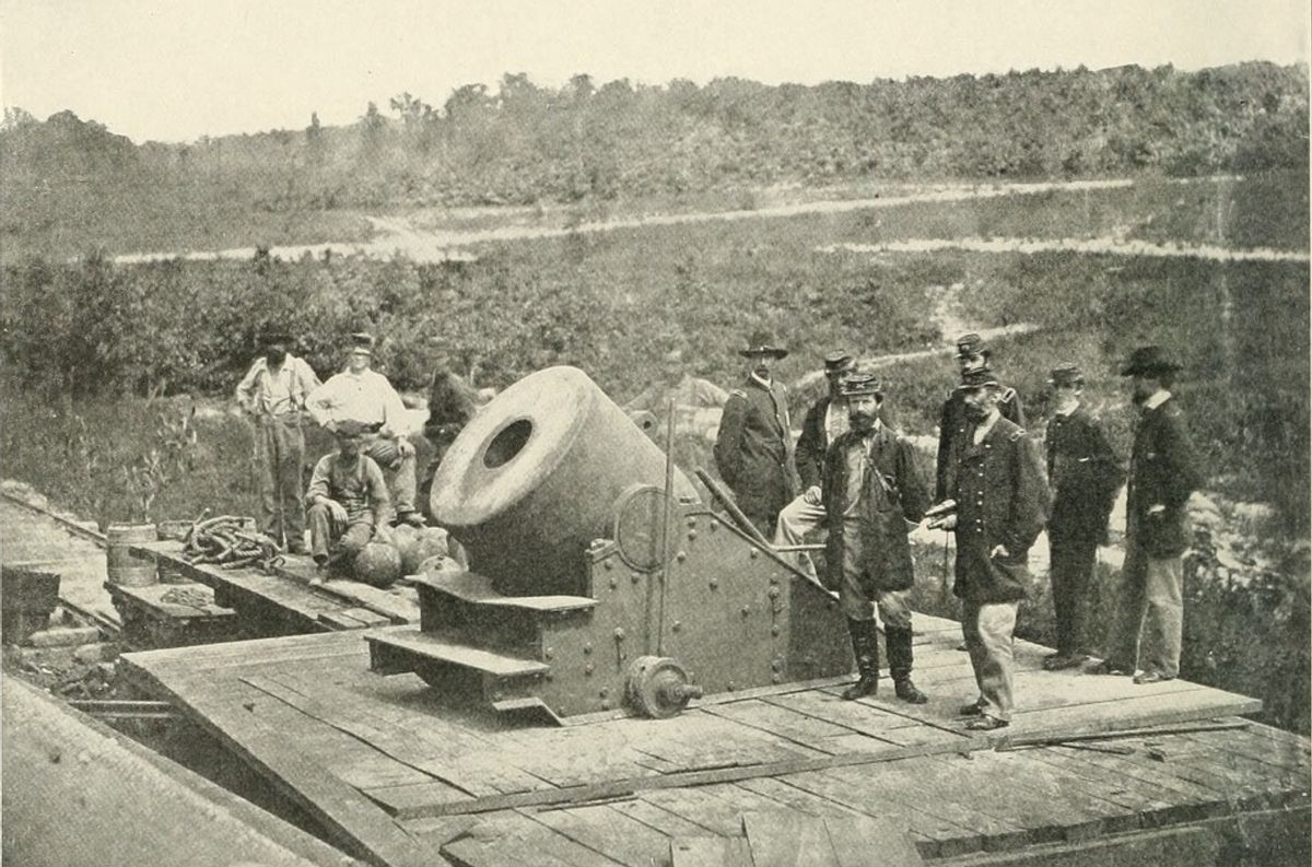 A grayscale image of men standing next to canons during the Civil War