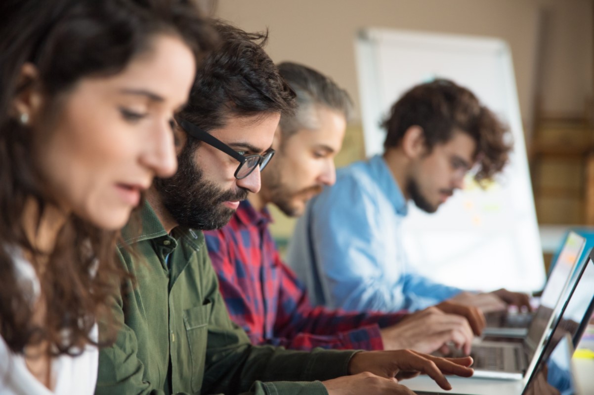 A group of students are pictured working side by side on a project