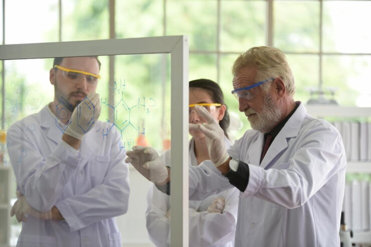 Several scientists are pictured working on a theory in her laboratory
