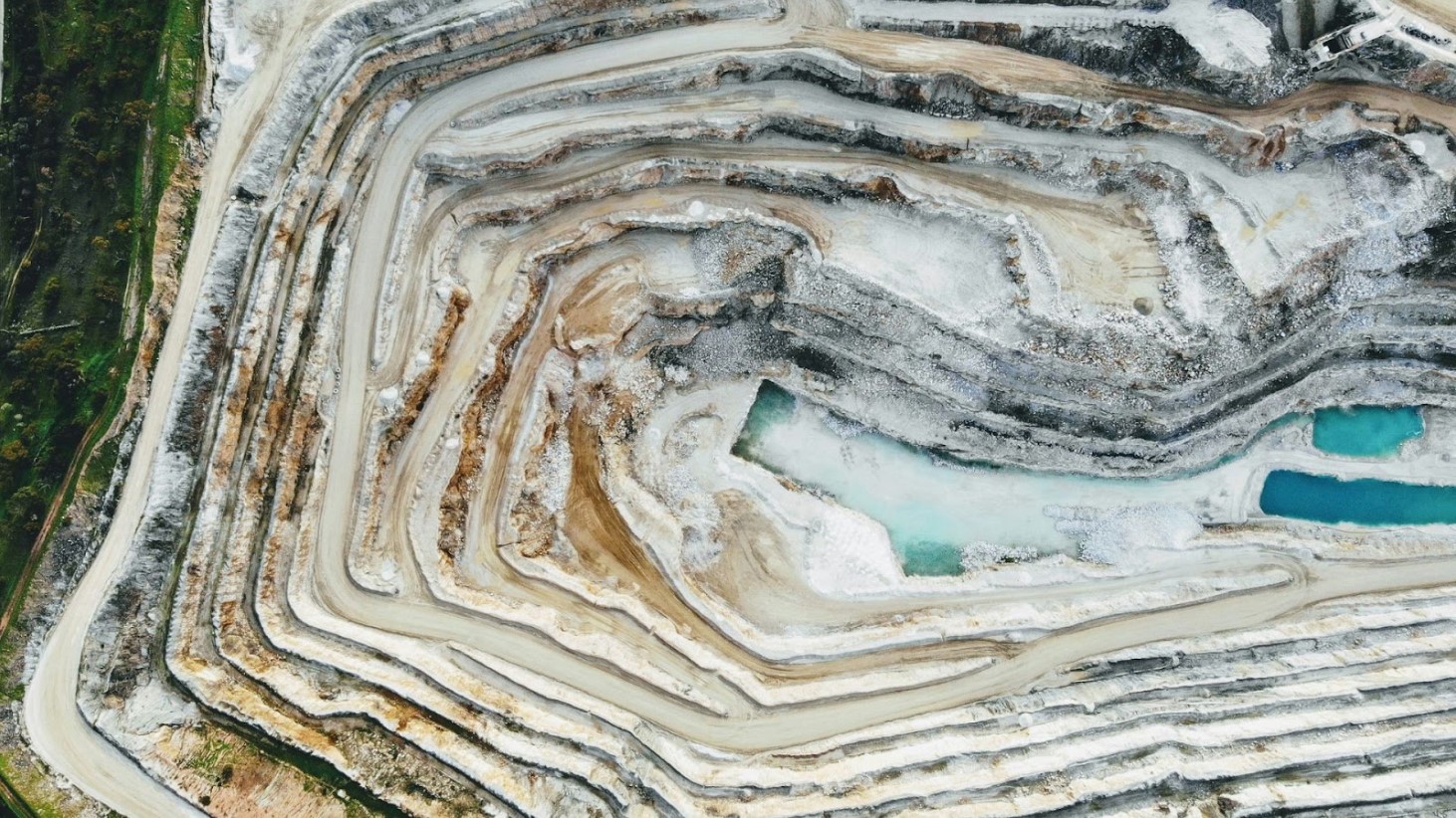 An aerial photograph displaying the expansive terraced layers of a large mining quarry