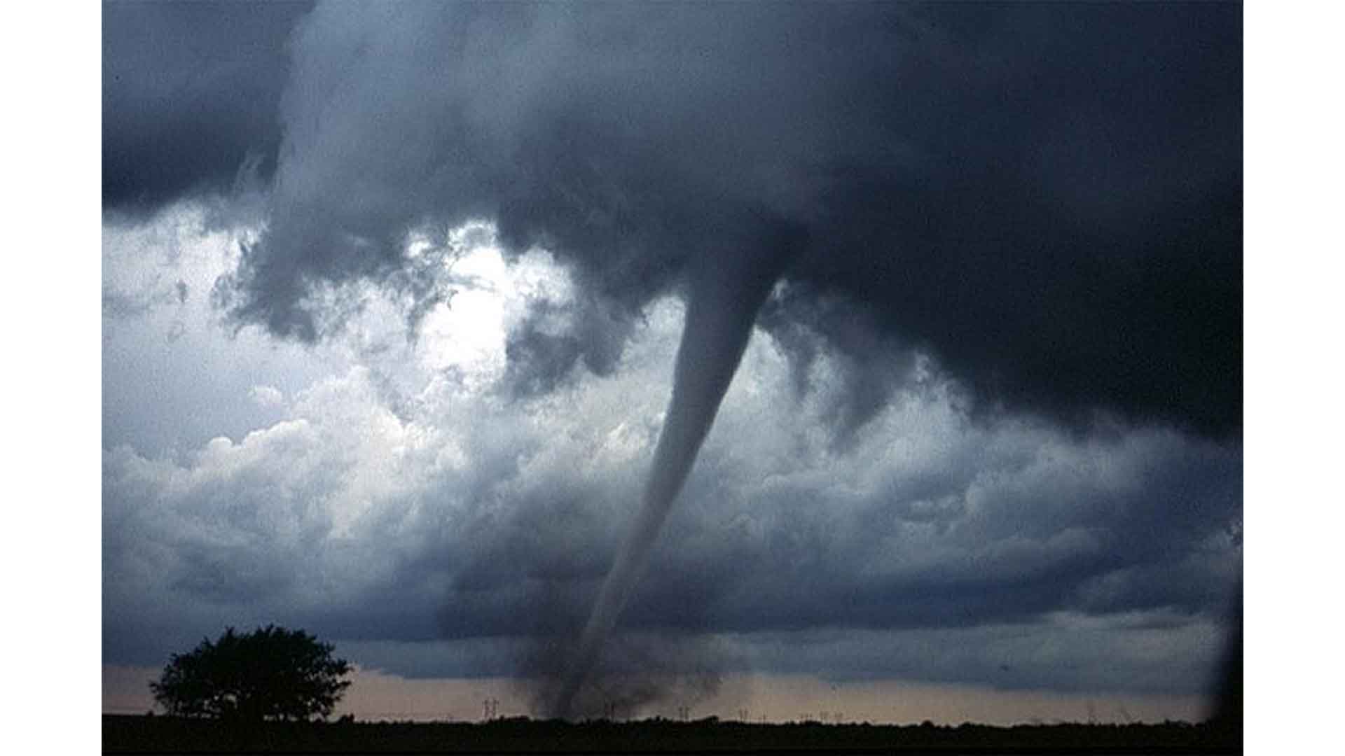 One of several tornadoes observed by the VORTEX-99 team on May 3, 1999, in central Oklahoma. Note the tube-like condensation funnel, attached to the rotating cloud base, surrounded by a translucent dust cloud.