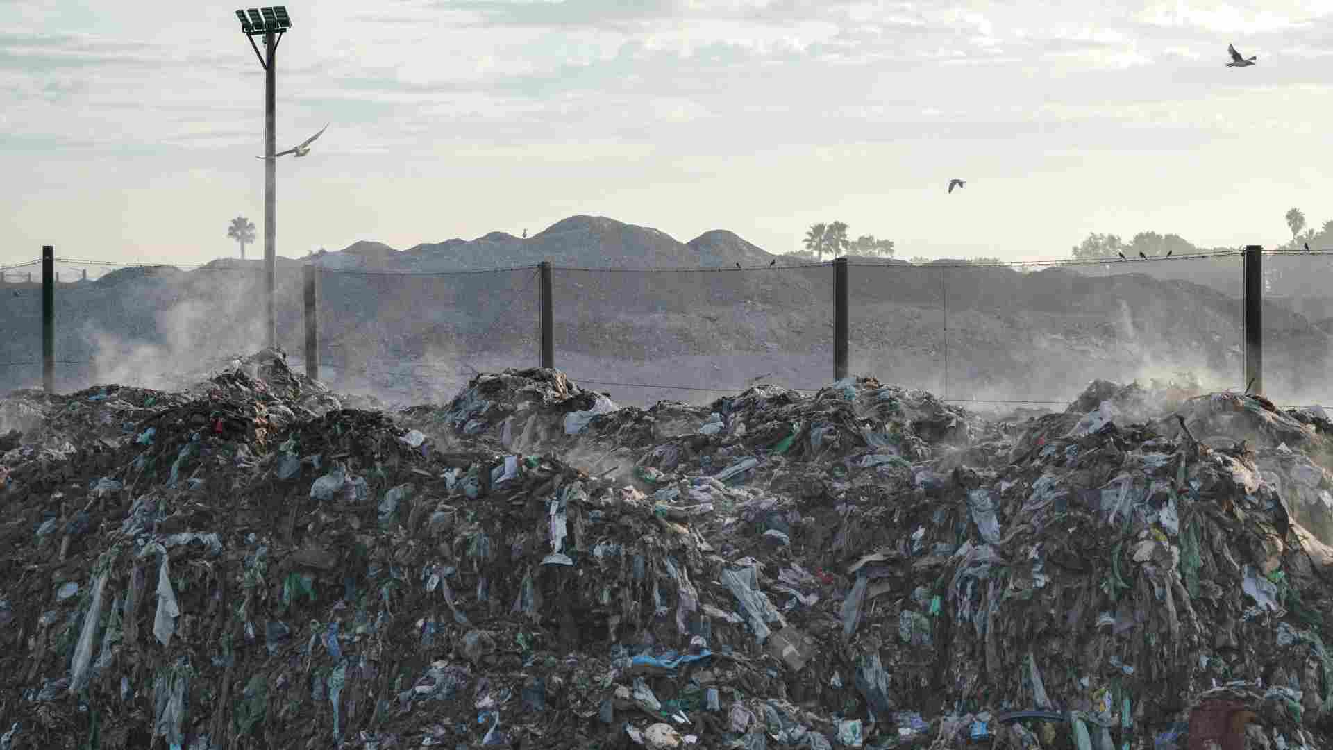 Piles of trash in a landfill area.