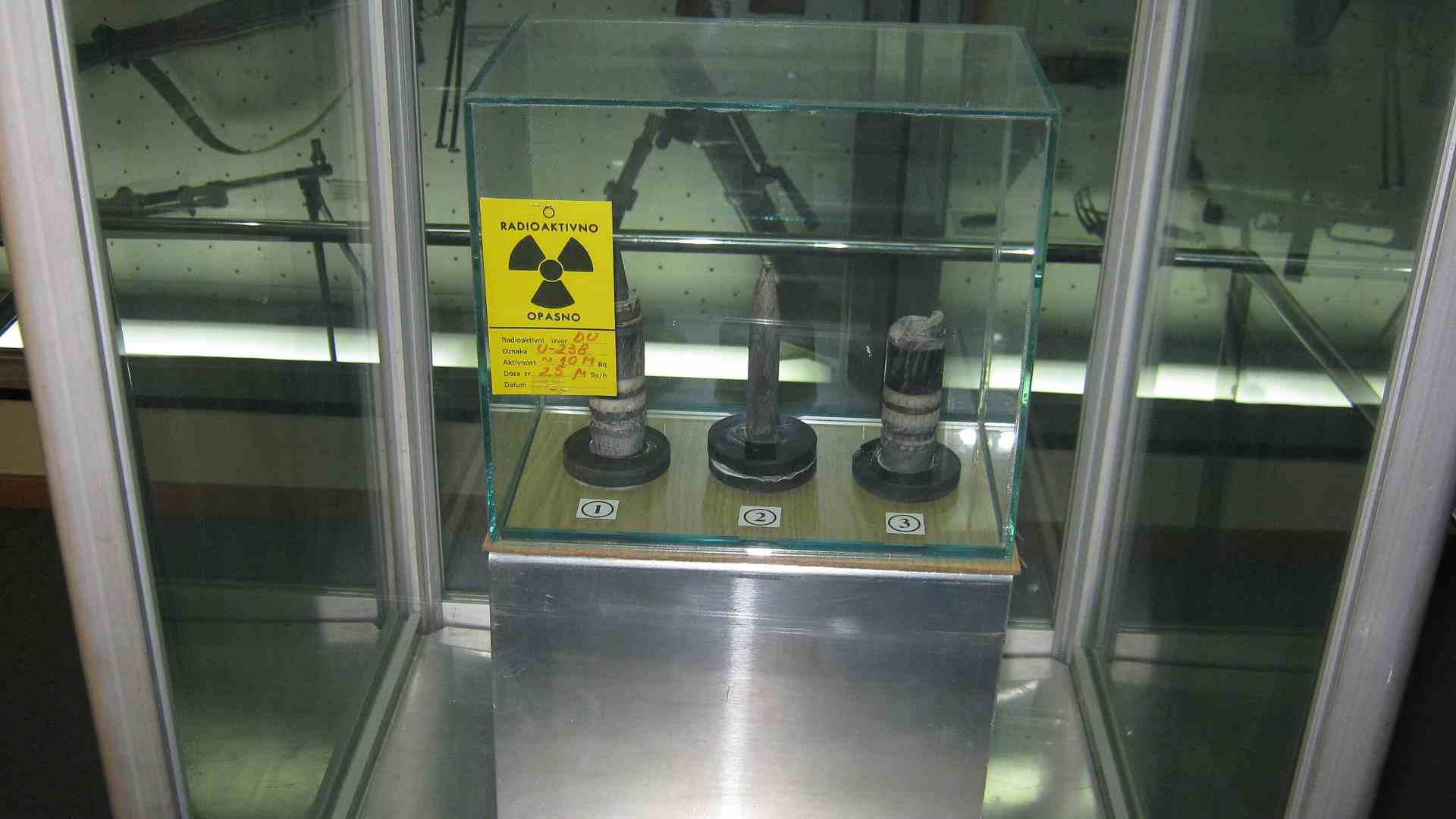 Spent Uranium sits behind protective glass.