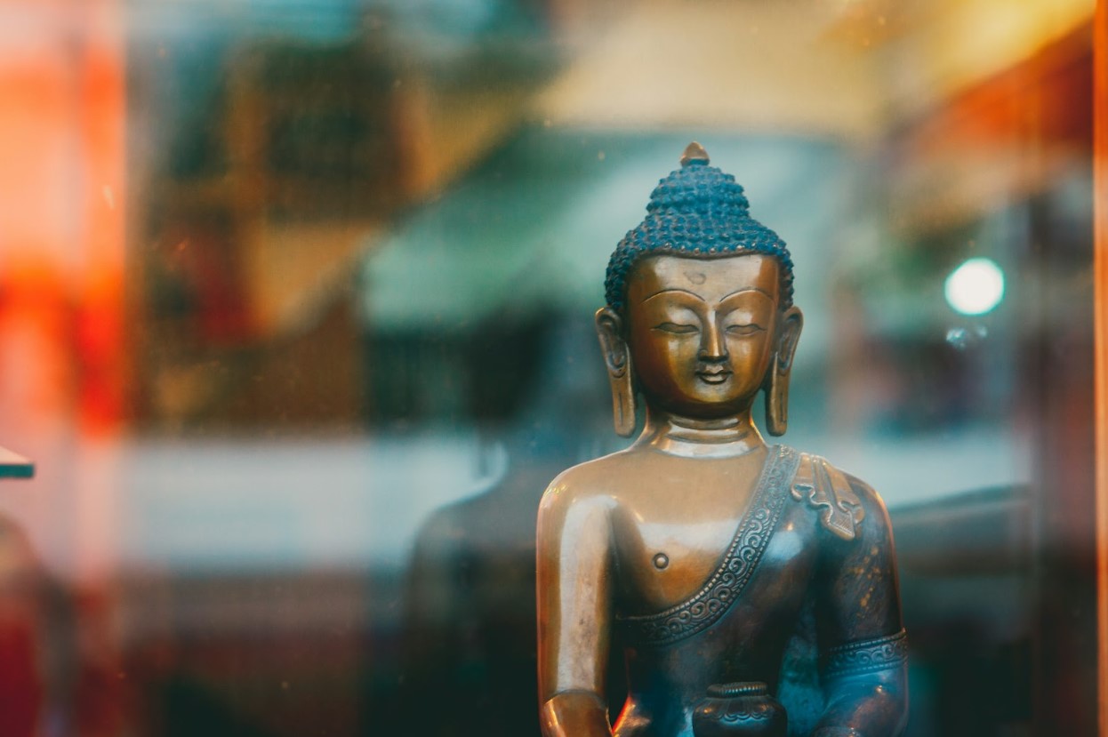 A Buddhist sculpture in front of a window