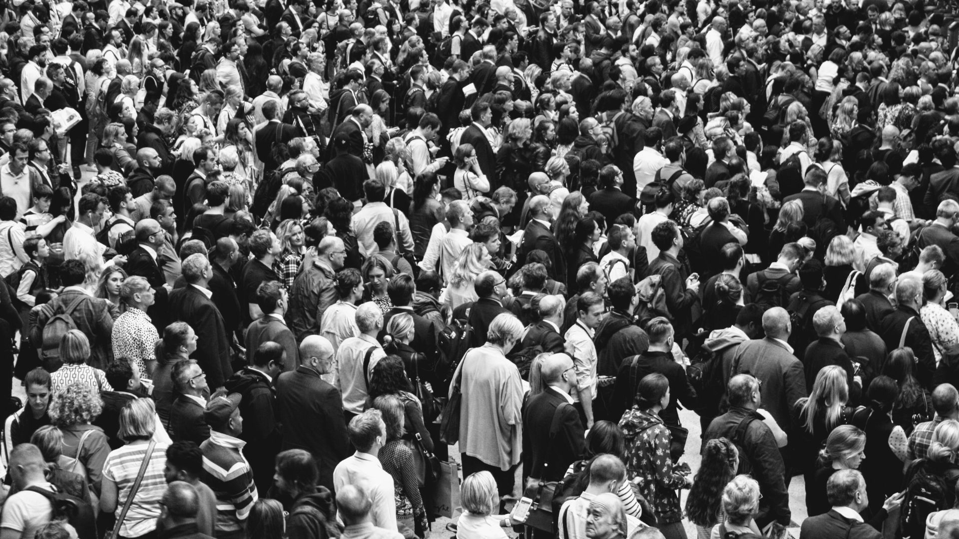 Black and white image capturing a dense assembly of people from an elevated perspective