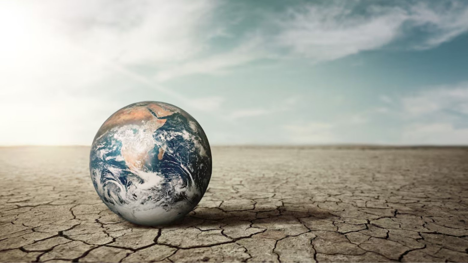 Digital illustration of climate change with a globe sitting on a dried-up field