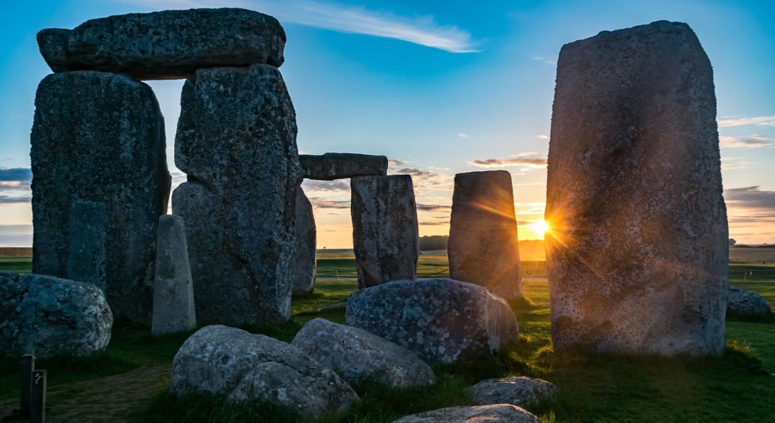 Stonehenge at sunset. There is a closeup of the stones, with the sun setting in between them.