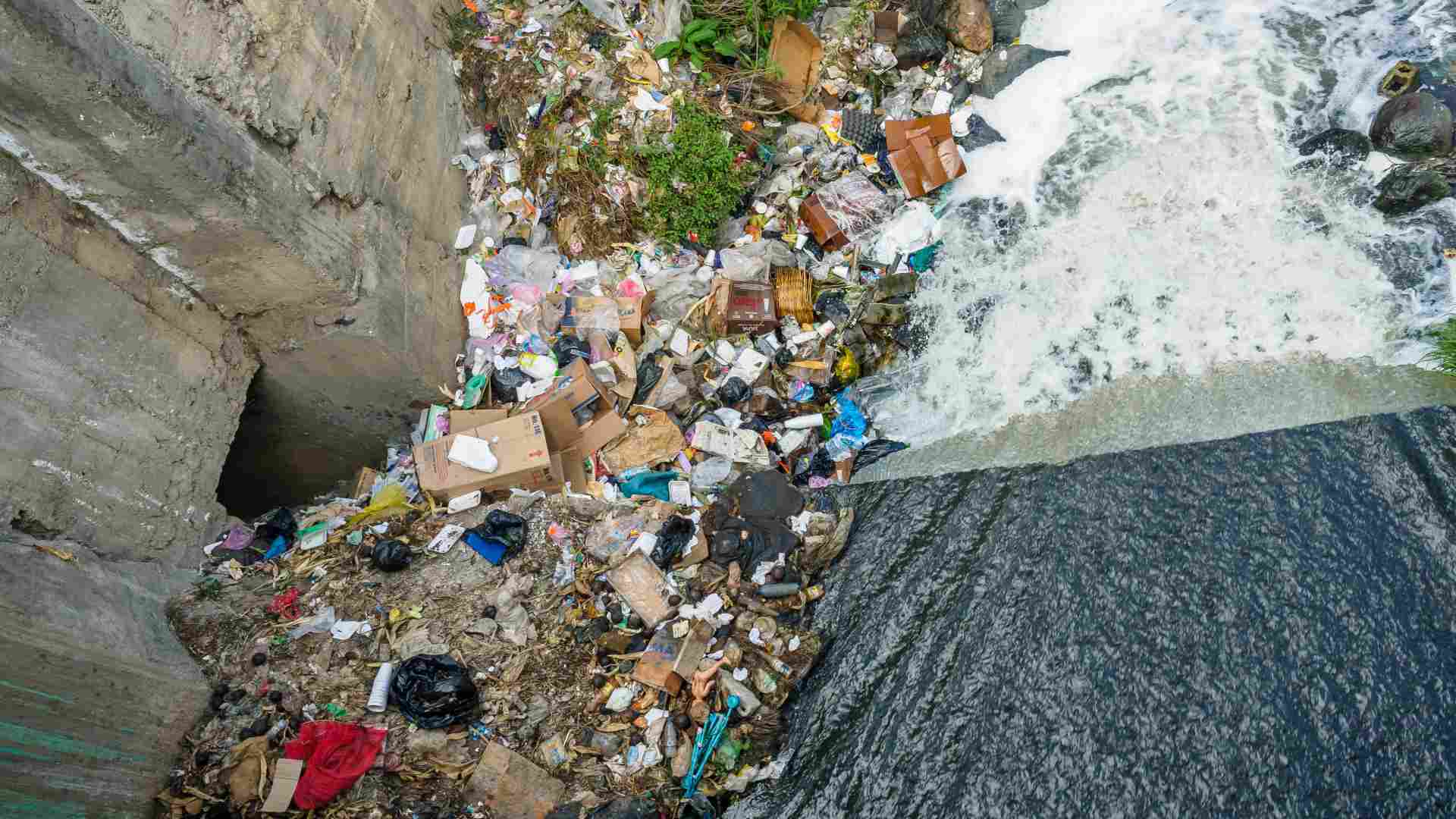 Water flows through a pile of trash.