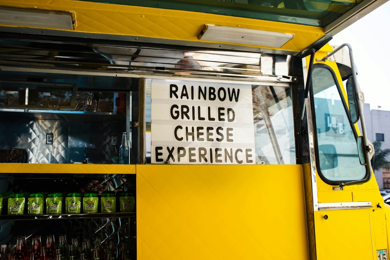 A yellow food truck offering a grilled cheese experience