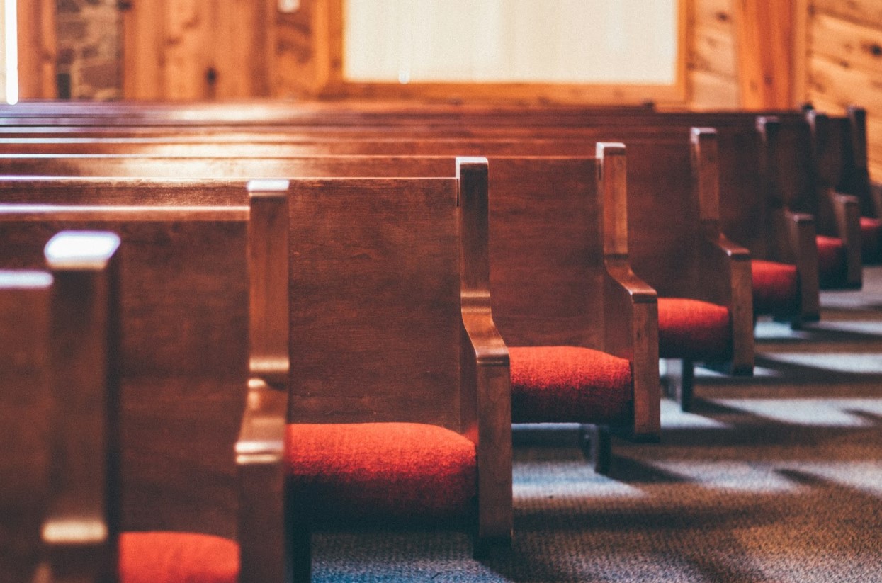 Rows of empty wooden pews inside a church