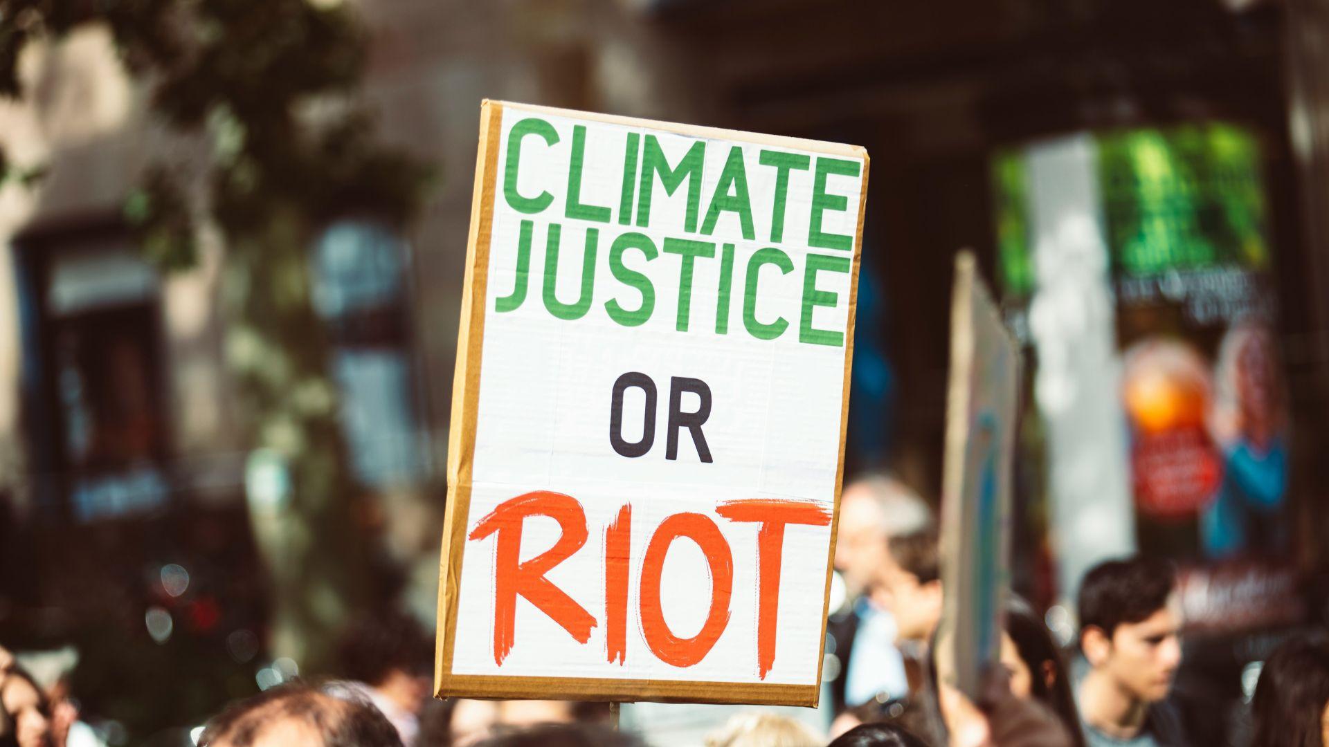 A protest sign about climate justice during an outside rally