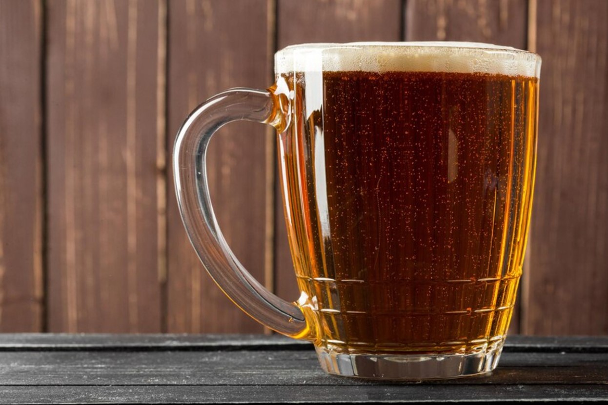 A large glass of beer on a wooden table