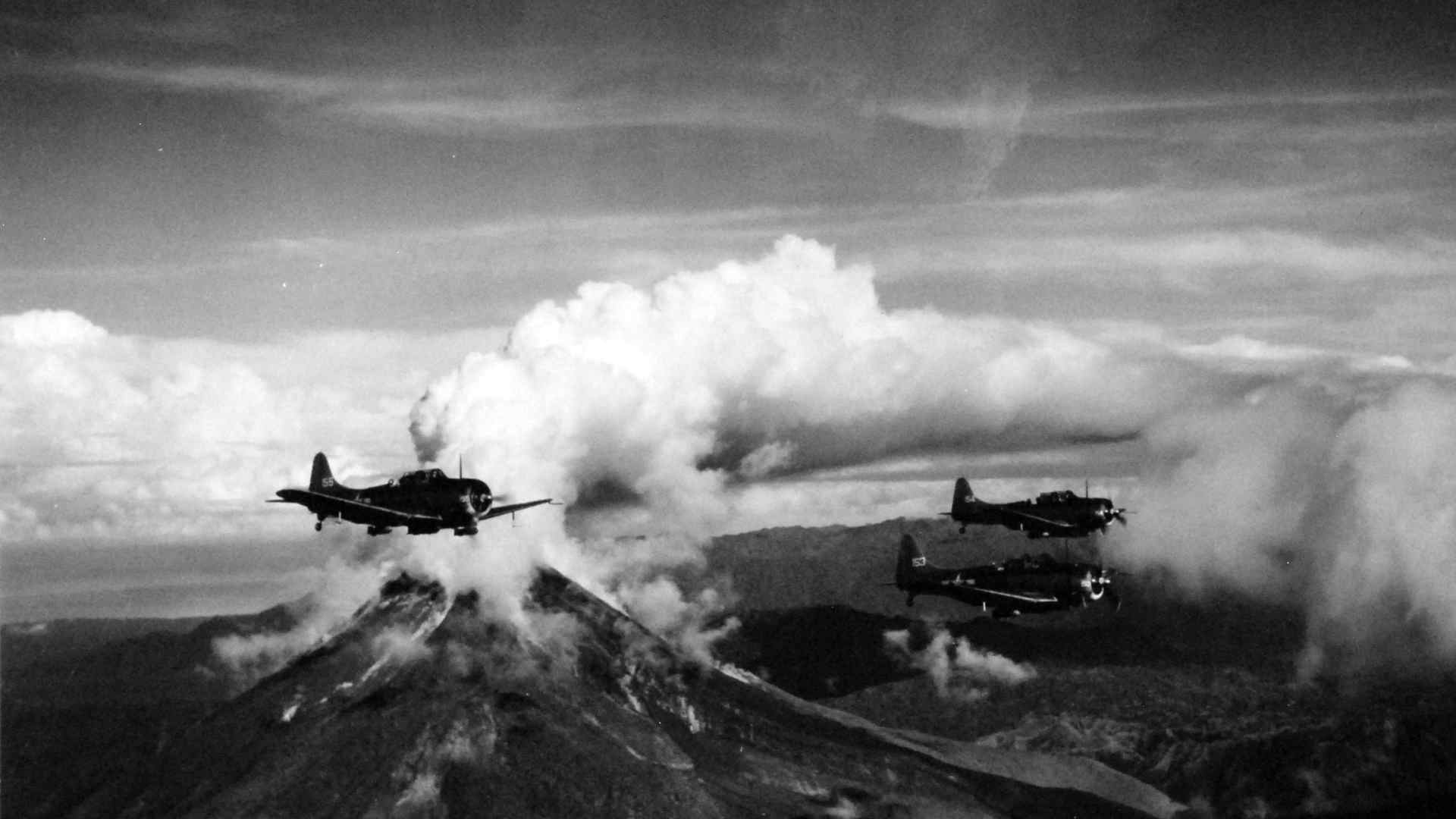 A WWII Marine Bombing plane passing over an active volcano.