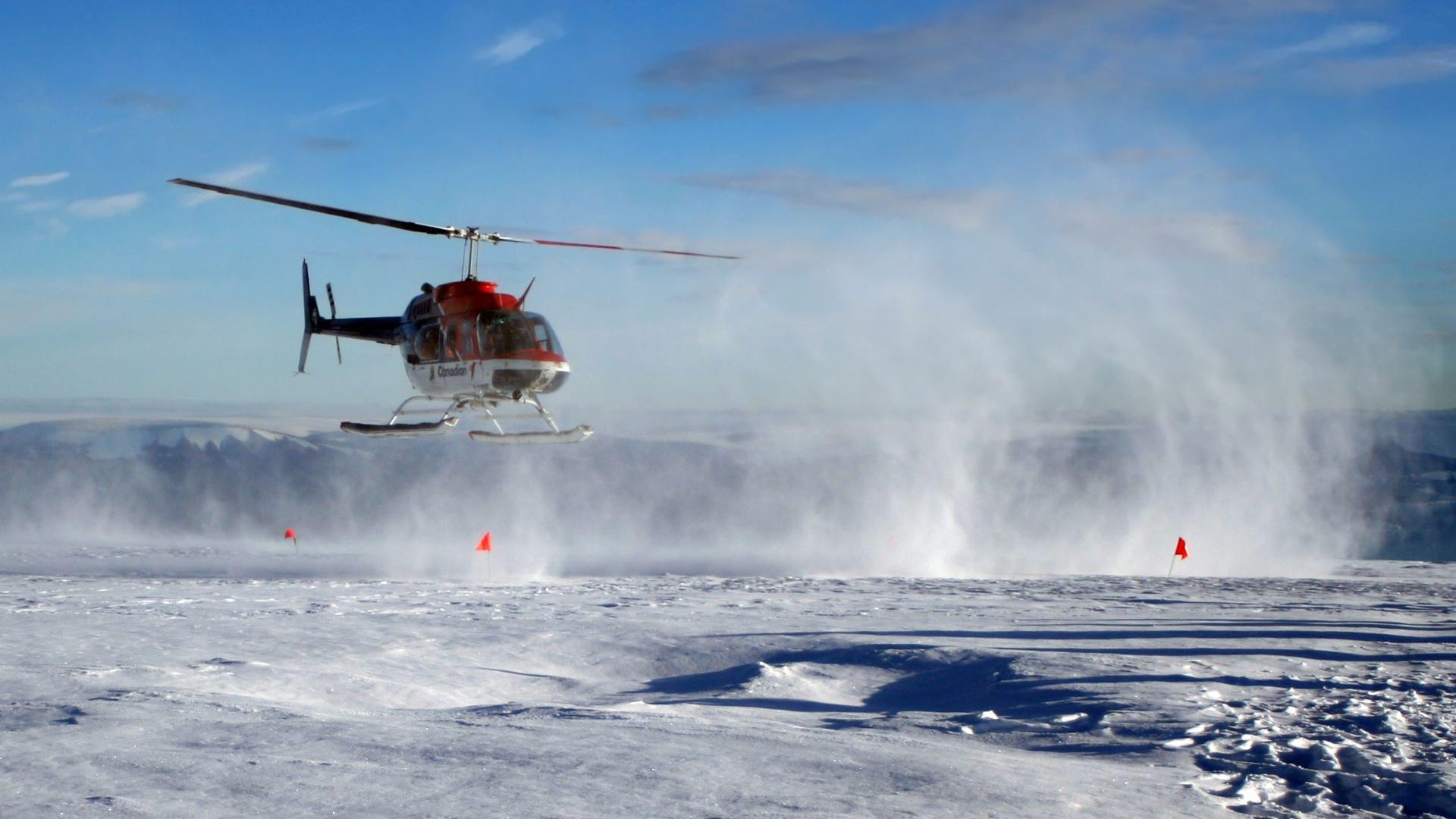 A cropped shot of a helicopter taking off from a Greenland ice sheet.
