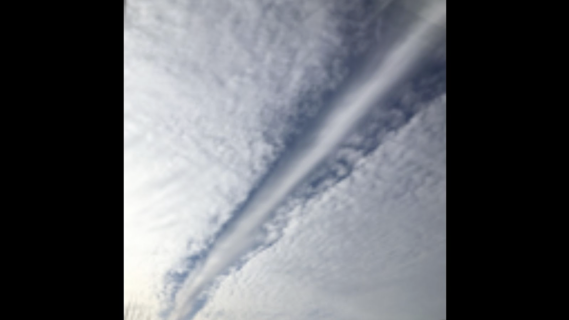 Example of a canal cloud, which is created when an airplane flies through altocumulus clouds at a shallow angle