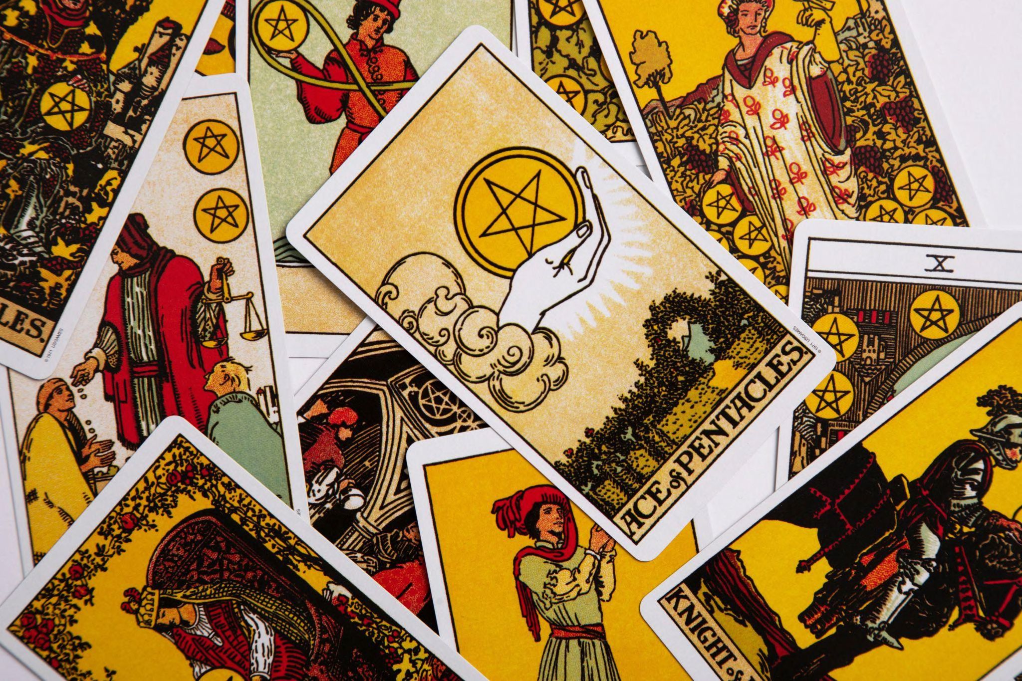 Many different tarot cards spread out on a surface.