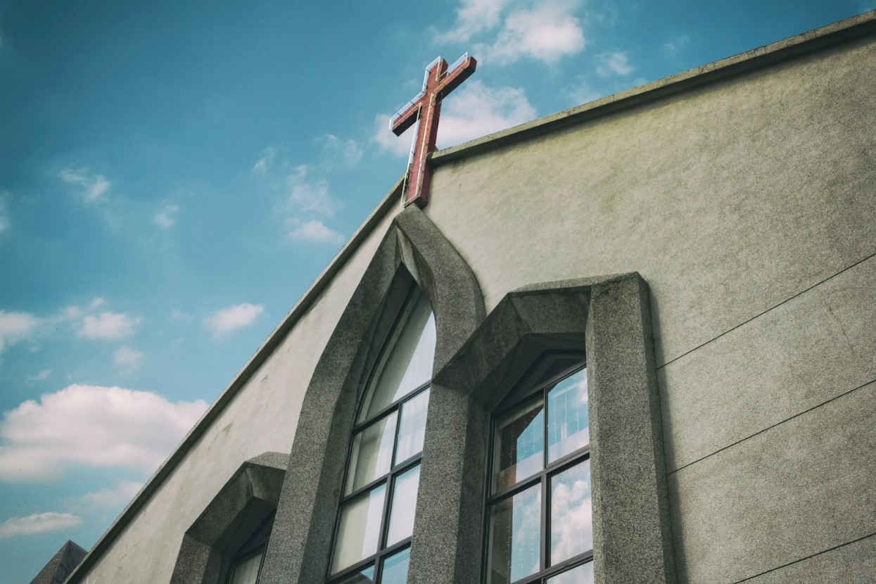 Arching church windows with a cross on top of it