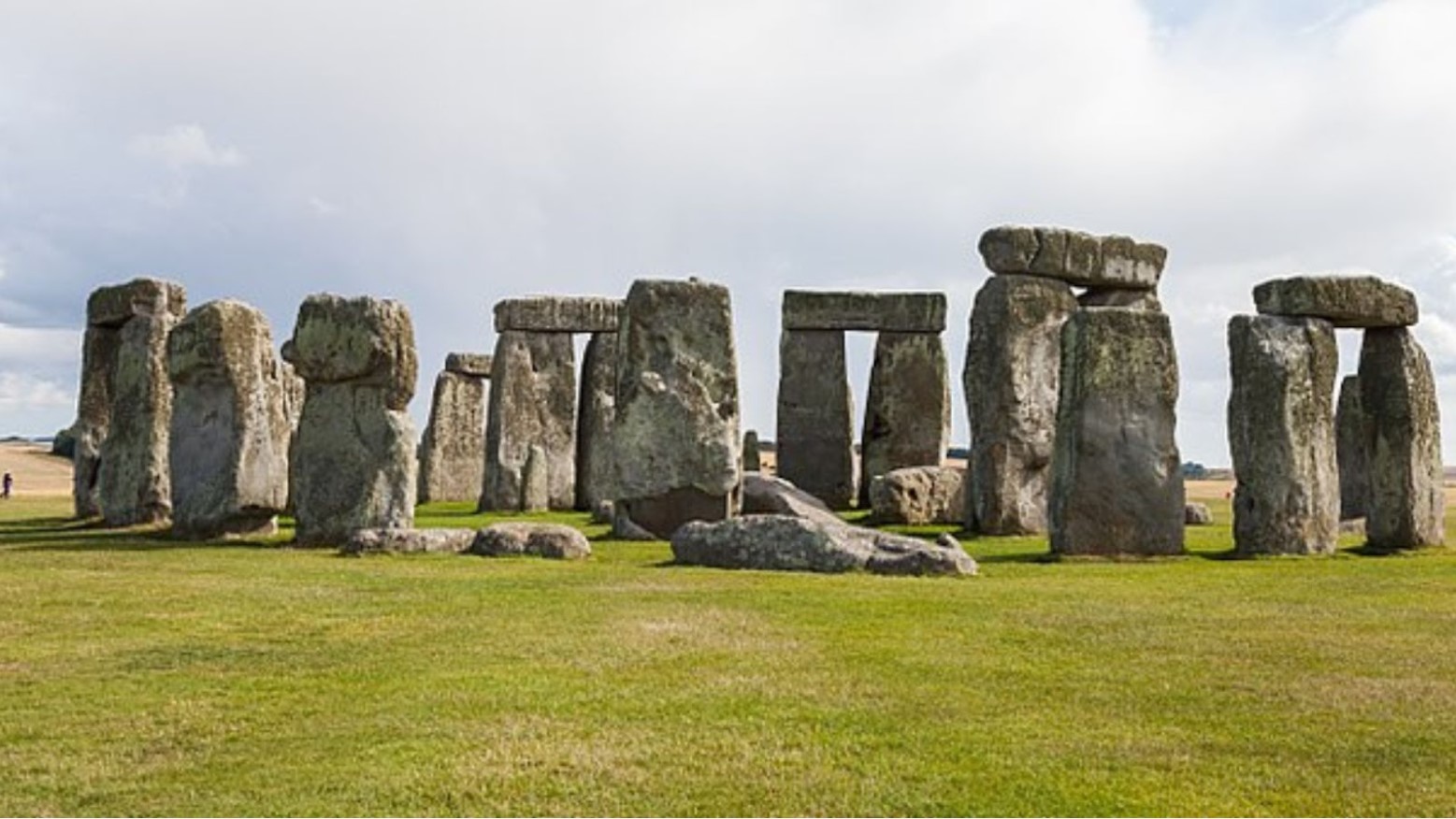 Stonehenge on a cloudy day. Most of the stones are standing upright, but there are some smaller ones that are lying on the floor.