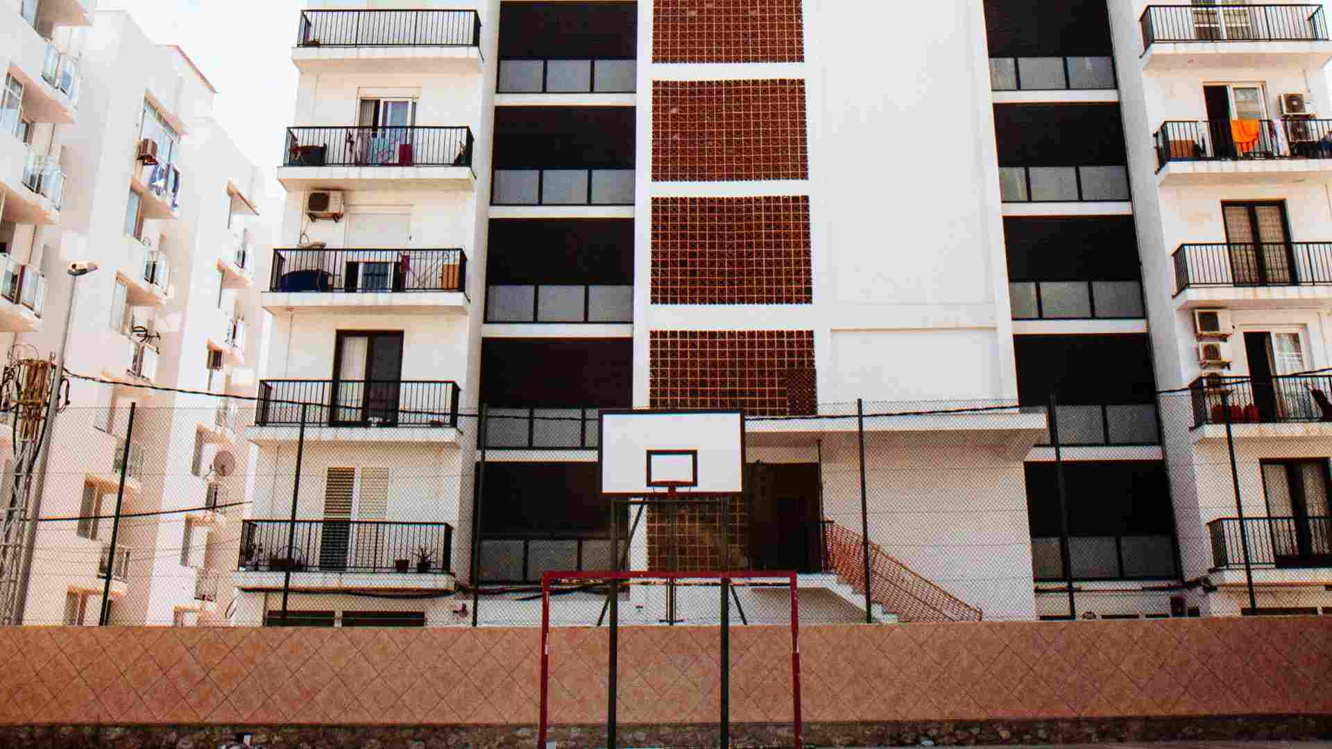 Apartments pictured behind a basketball court.