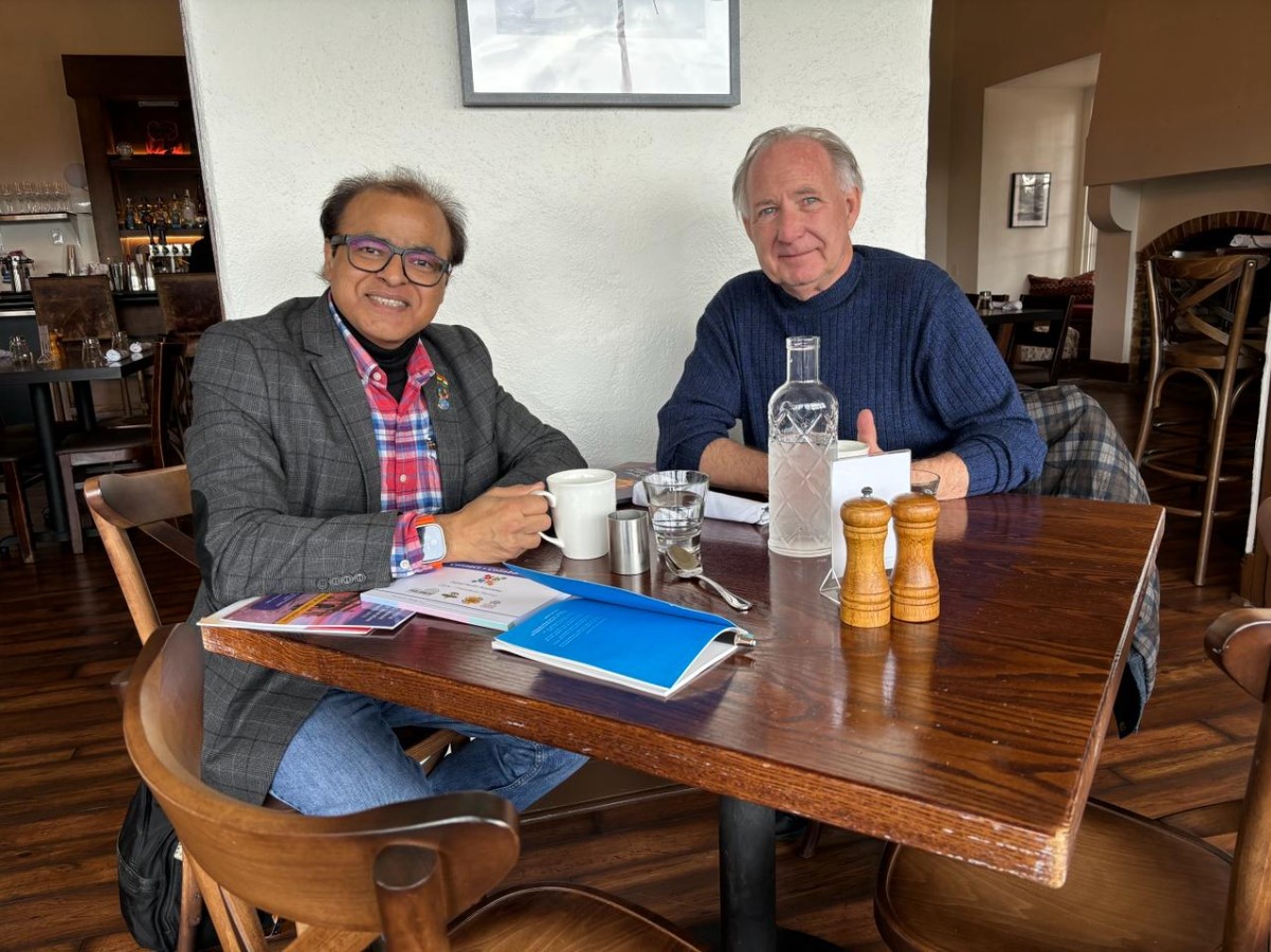 Rajendra Gupta, a physics professor, is pictured seated at a table alongside a colleague