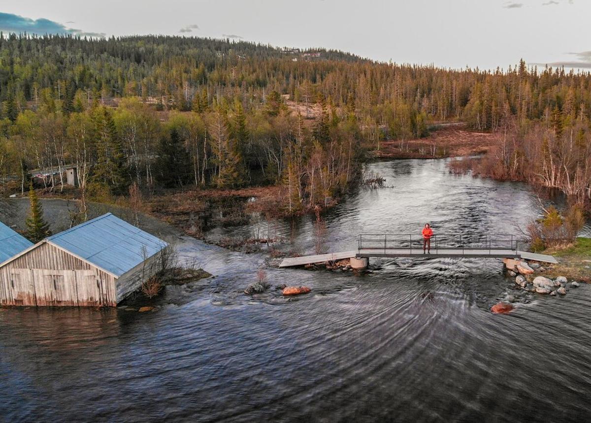 Man stands on a footbridge during a flood