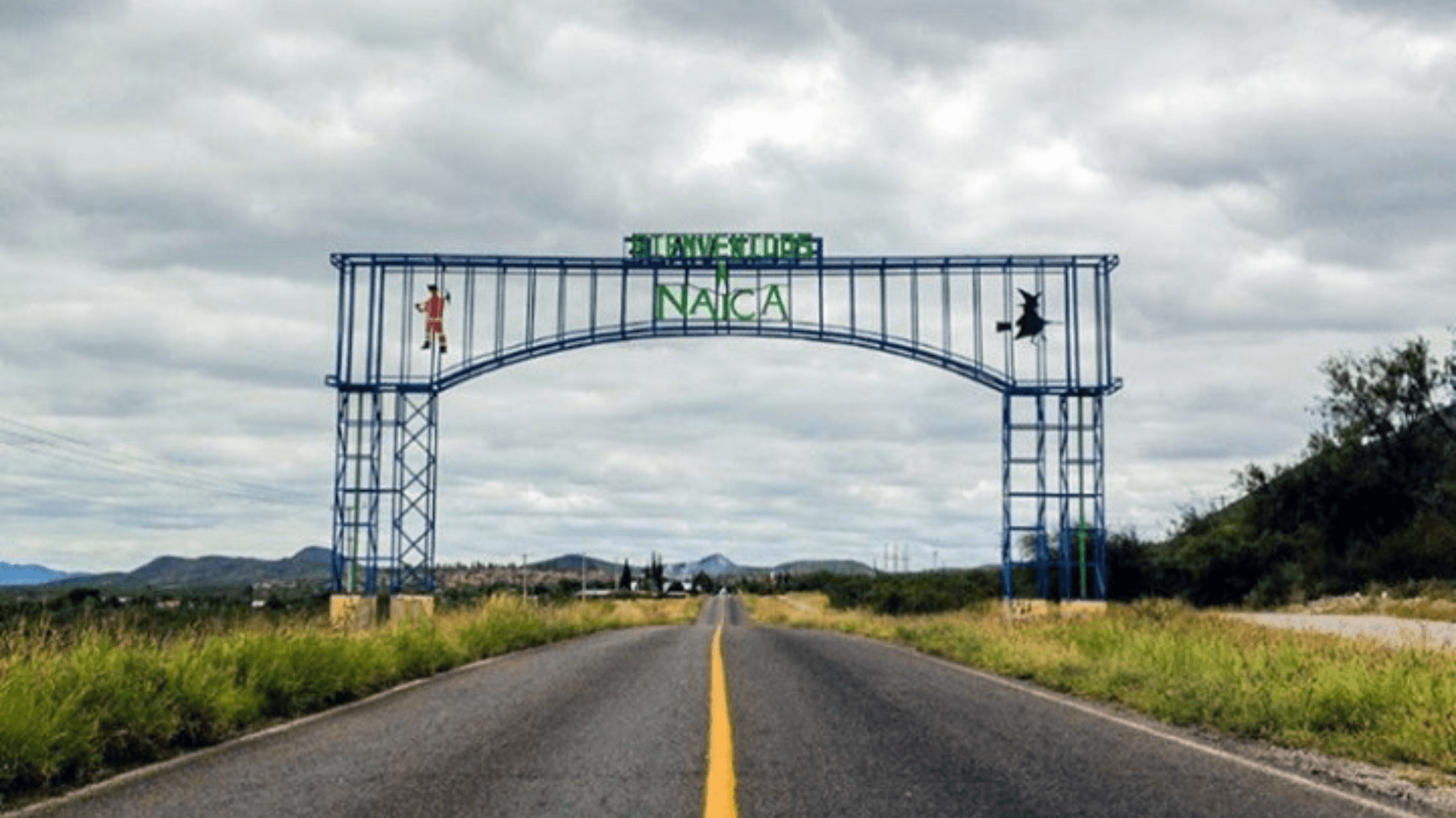 The entrance to Naica, Mexico, showing an archway with “Naica” written on it and a long highway.