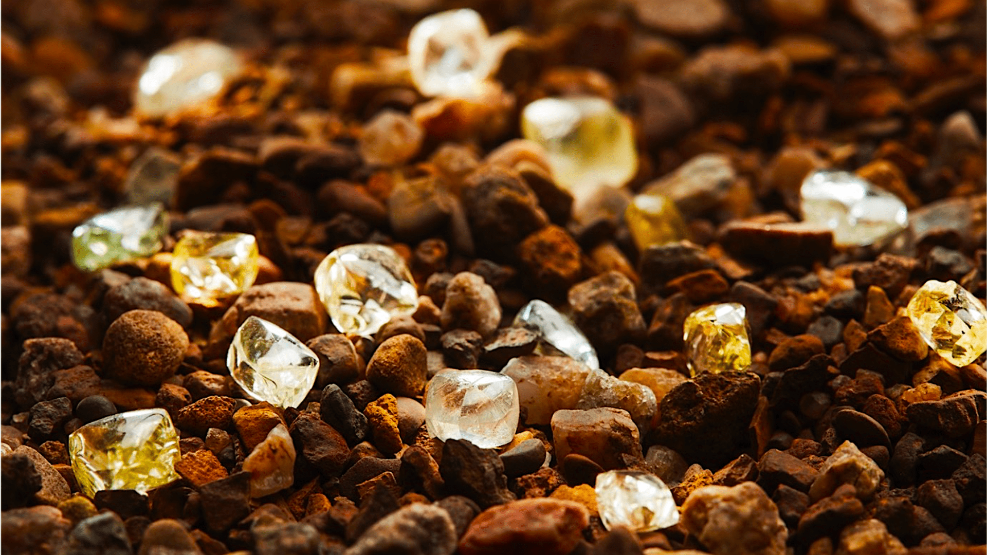 Diamonds scattered amongst small brown and orange stones.
