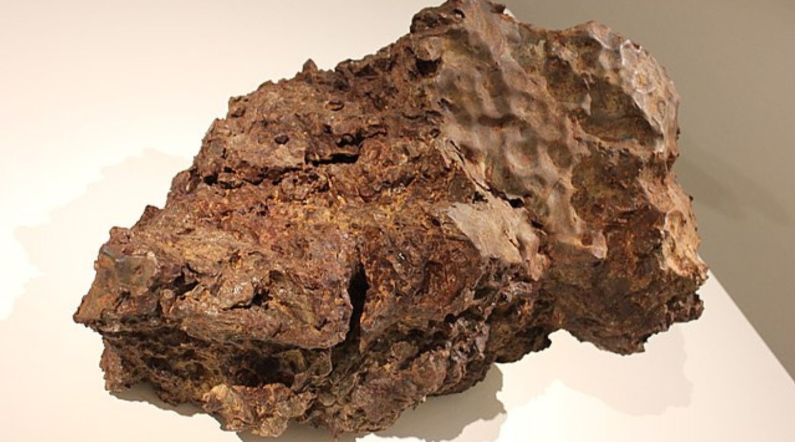 An image of a meteorite that has been placed on a white surface.