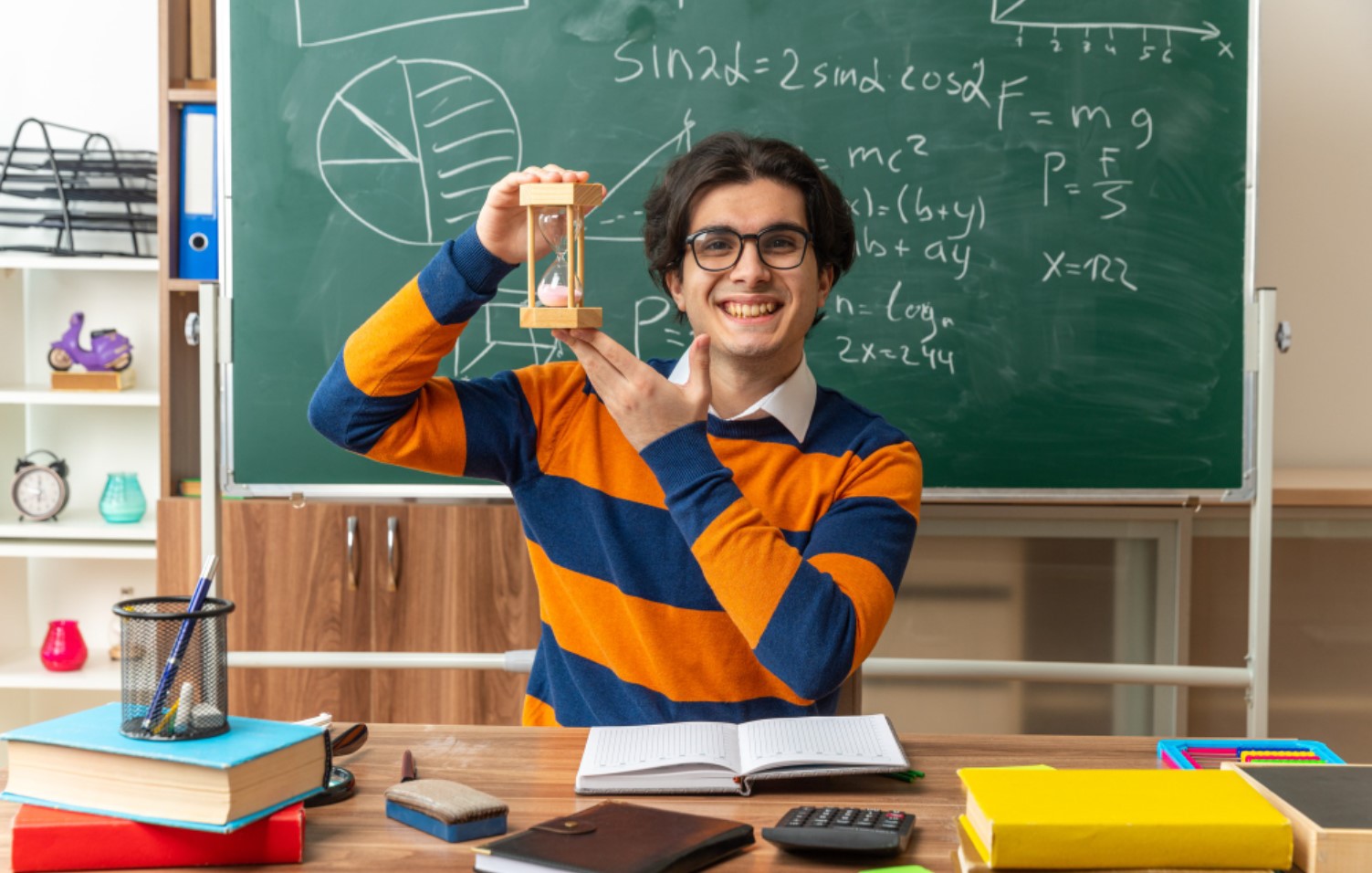 An image of a male science teacher holding up an hourglass