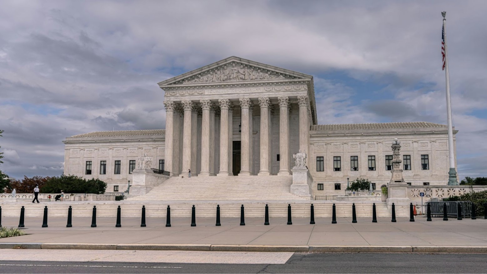 The U.S. Supreme Court building seen underneath a cloudy blue sky.