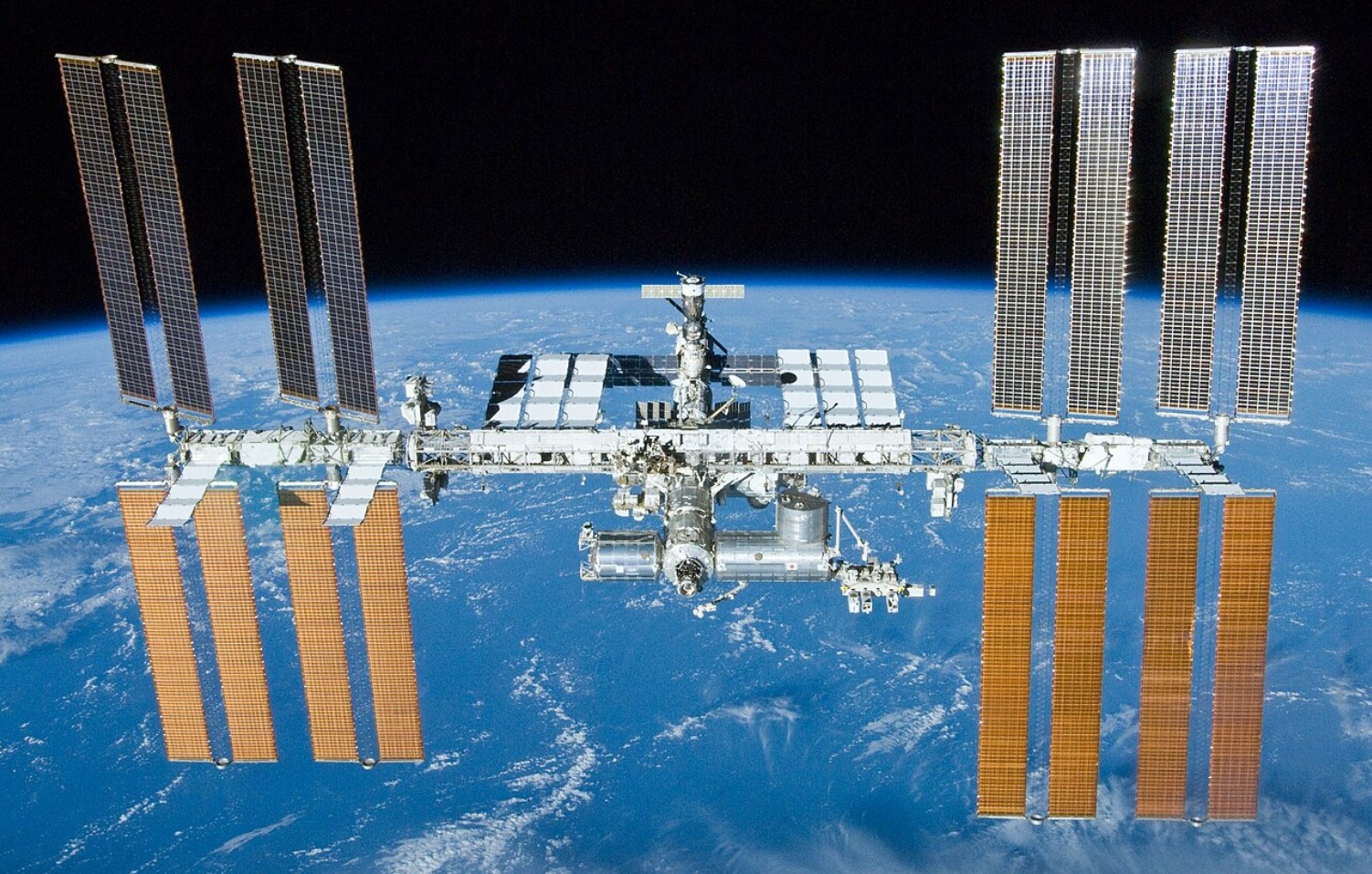 An image of the International Space Station floating above Earth