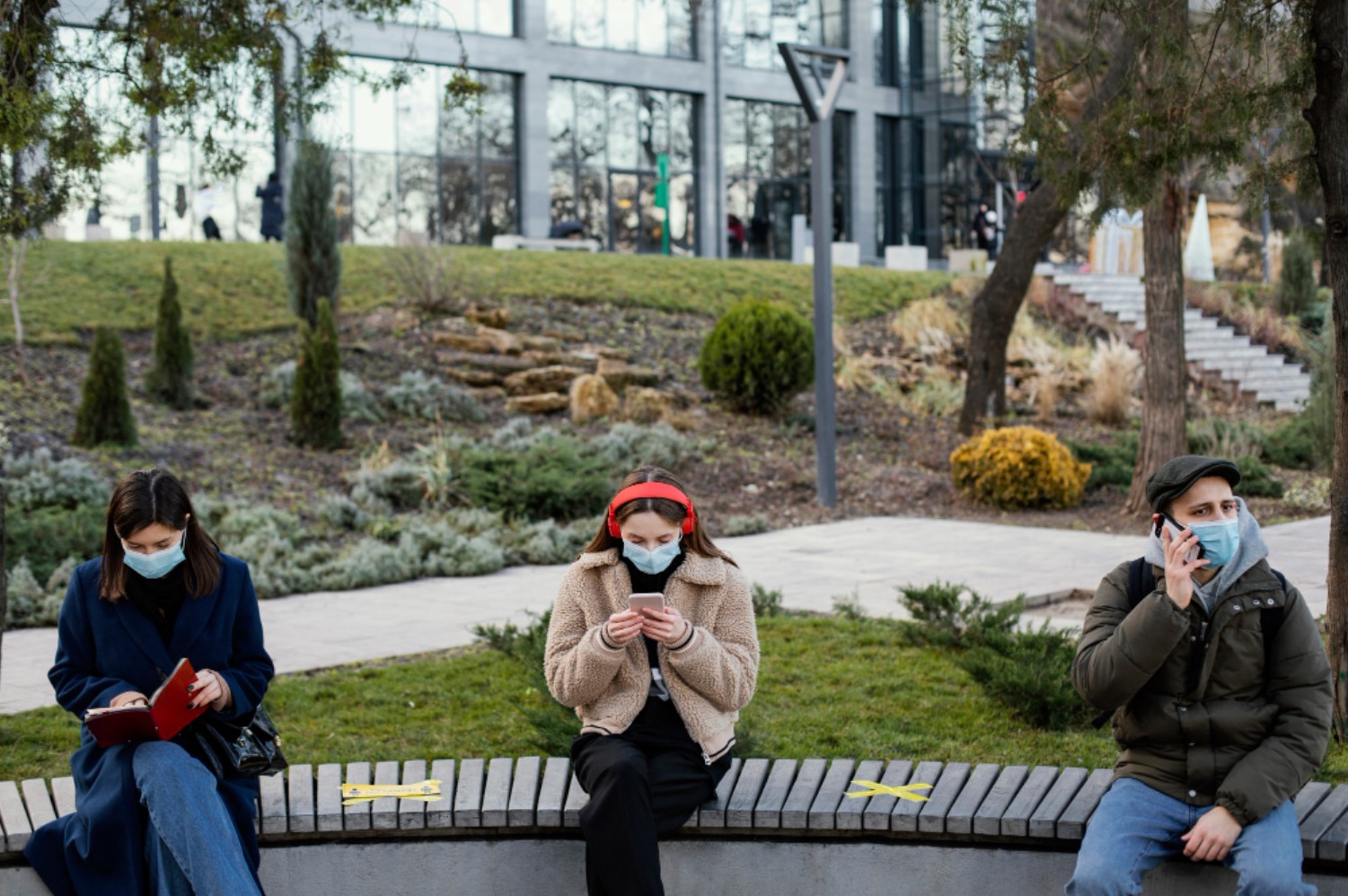 An image of three people sitting on a bench during the Covid-19 pandemic