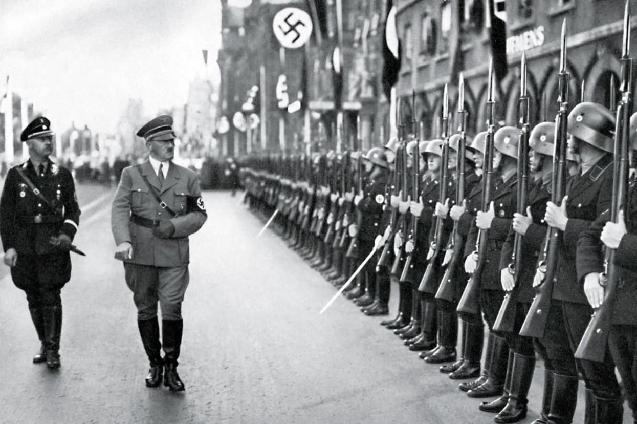 Adolf Hitler walks along a straight line of Nazi soldiers