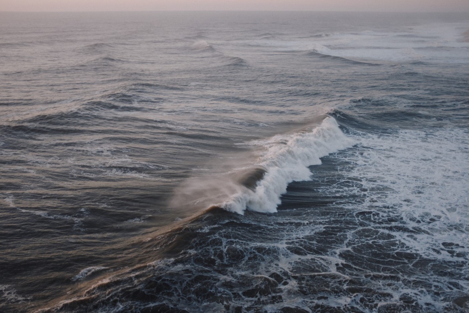 An image that depicts several large waves crashing in an ocean