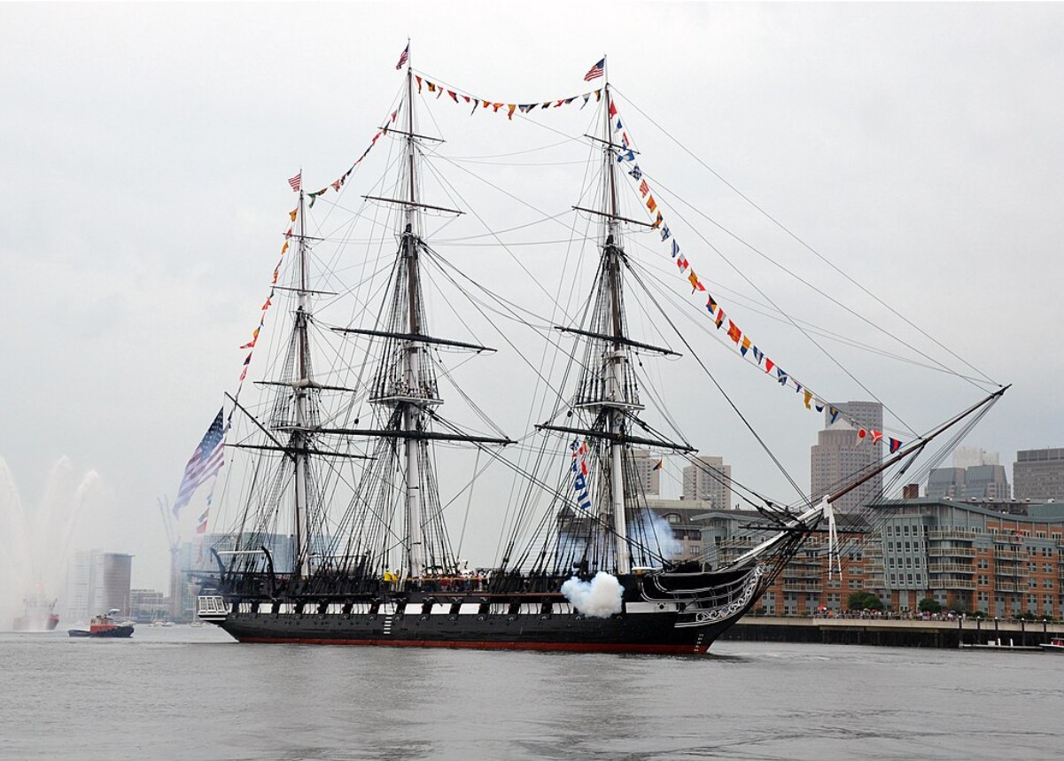 An image of the USS Constitution in a city’s harbor
