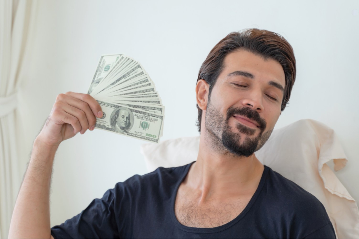 A man is pictured holding a large sum of American bills