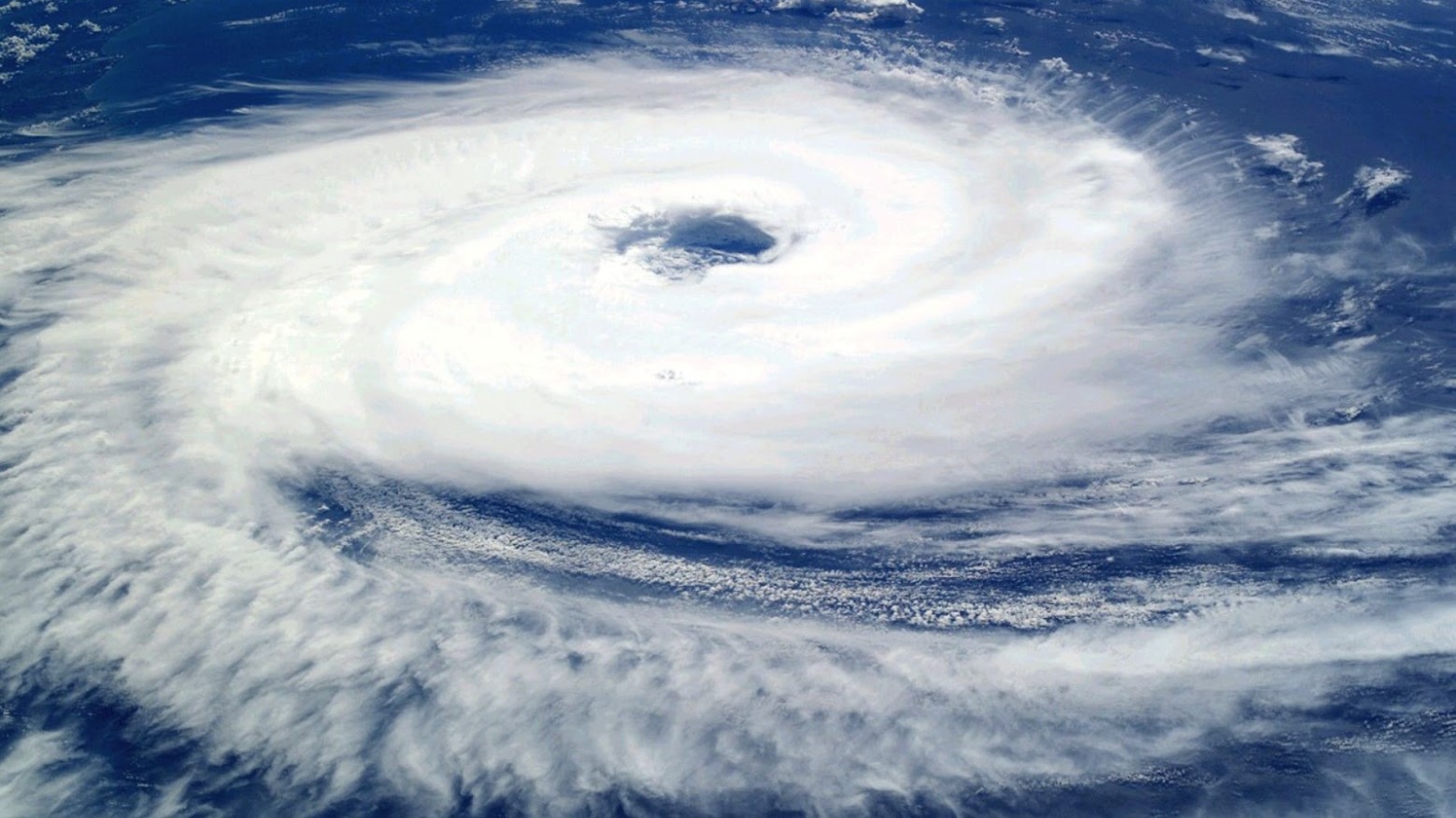 Aerial image of a typhoon. The image shows a cloud spinning around against the blue sea.