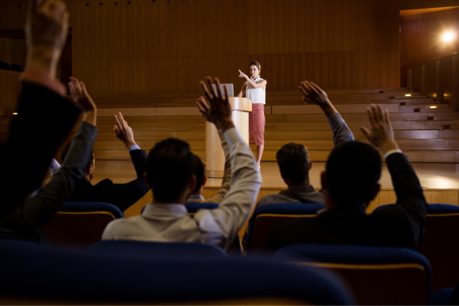 An image of several people with their hands raised at an auction