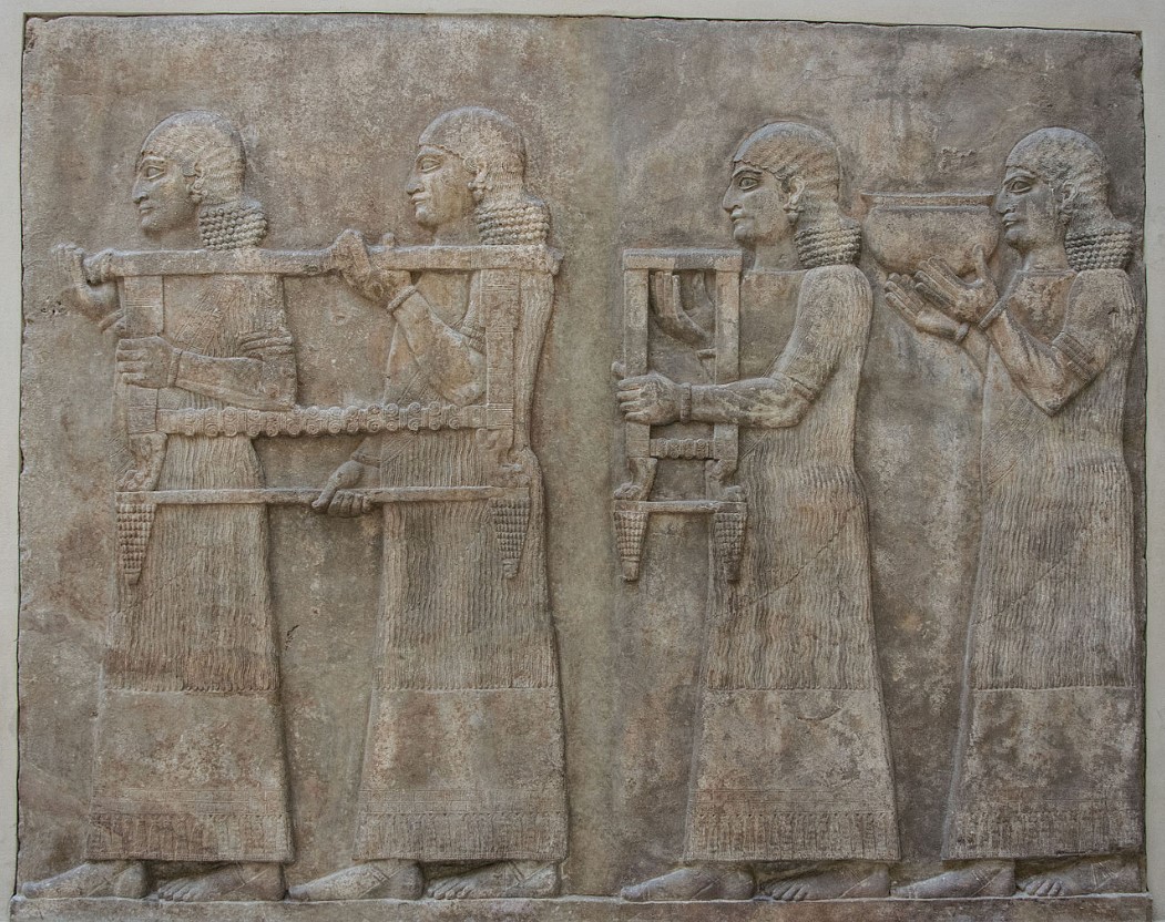 An image of several Assyrian men carrying furniture