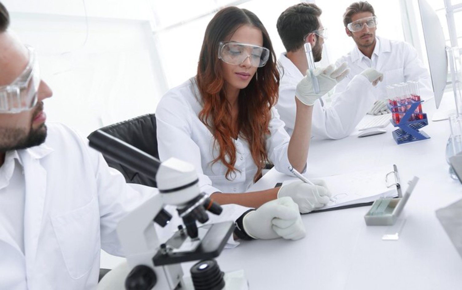 Several scientists are pictured working on research in their lab