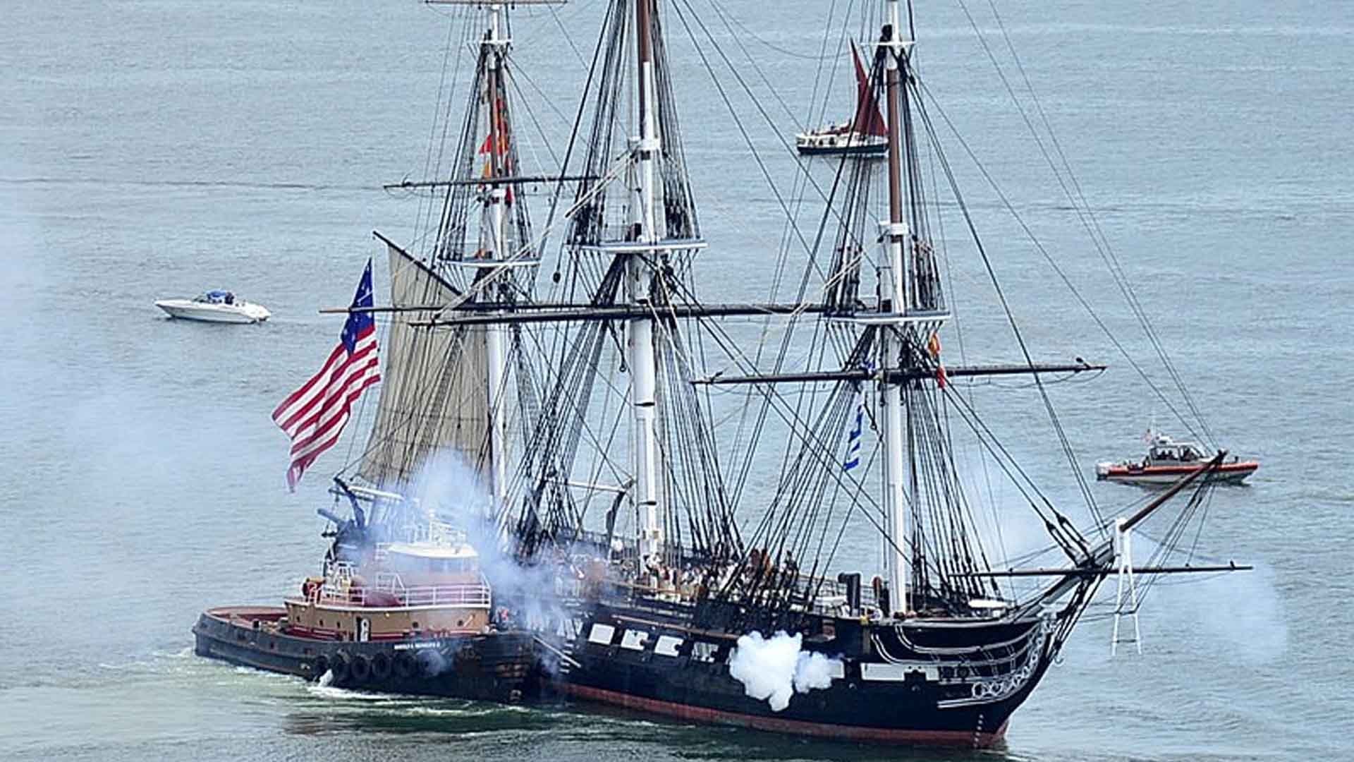 Constitution fires her cannons as she is tugged through Boston Harbor in 2021.