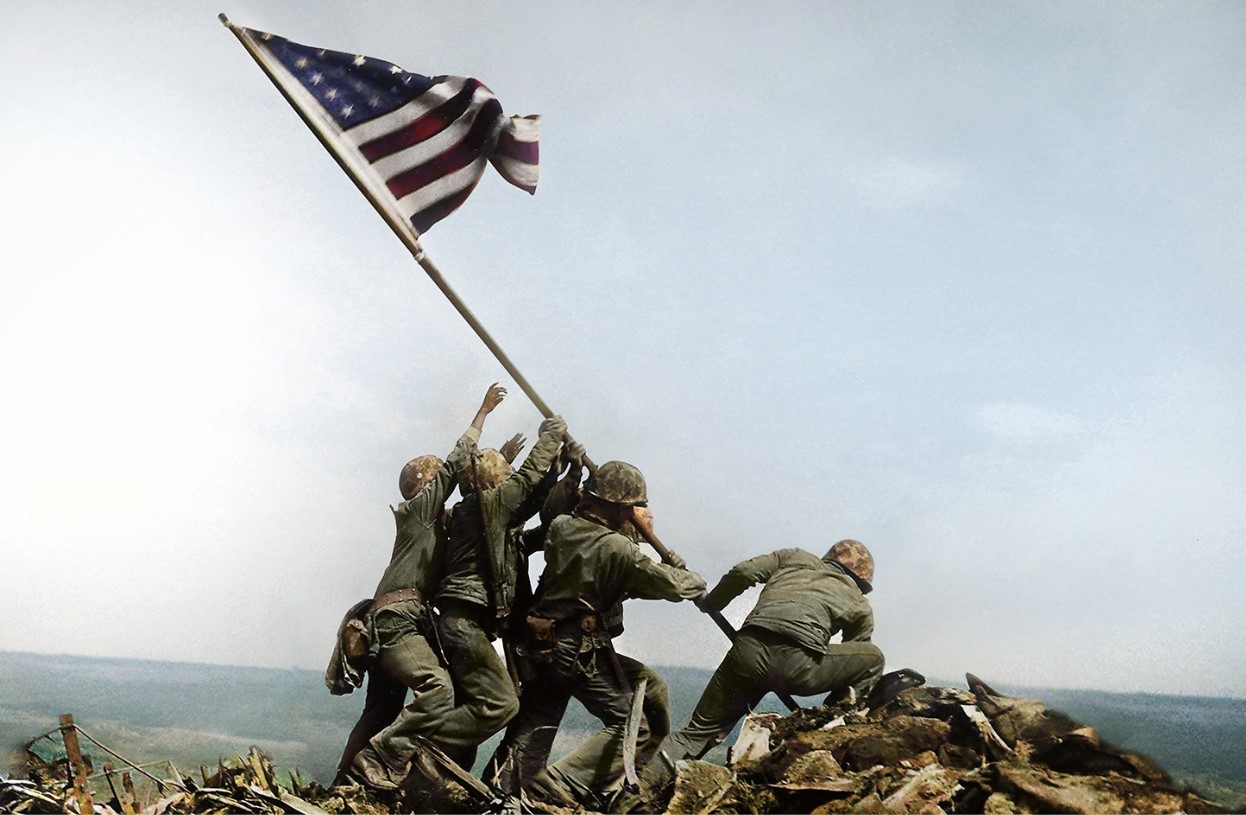 Photograph of American soldiers raising an American flag during WWII